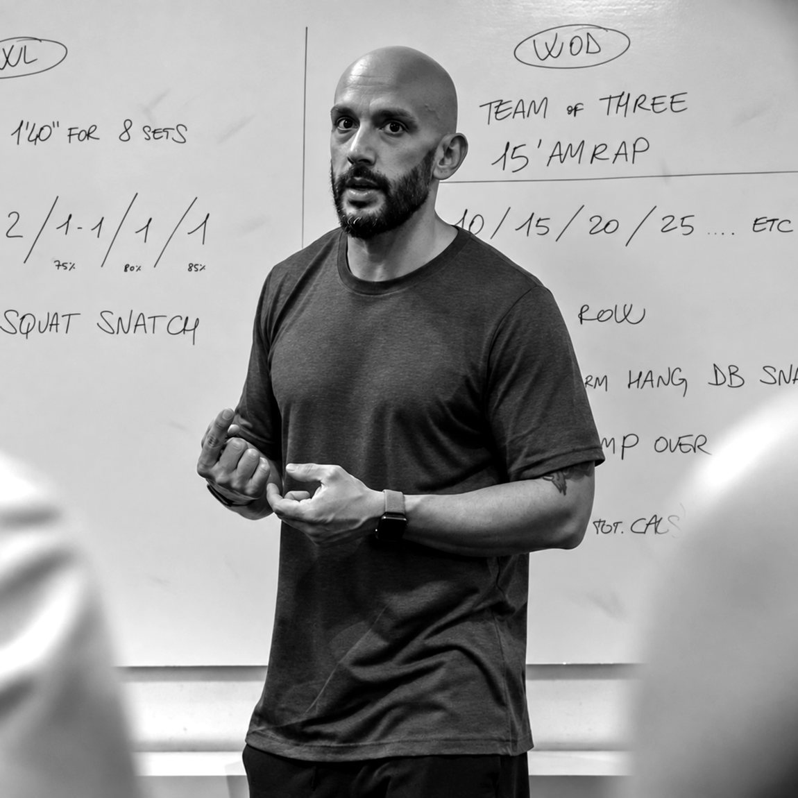 Stefano Consolo, coach CrossFit a Milano, spiega il WOD alla lavagna durante una classe